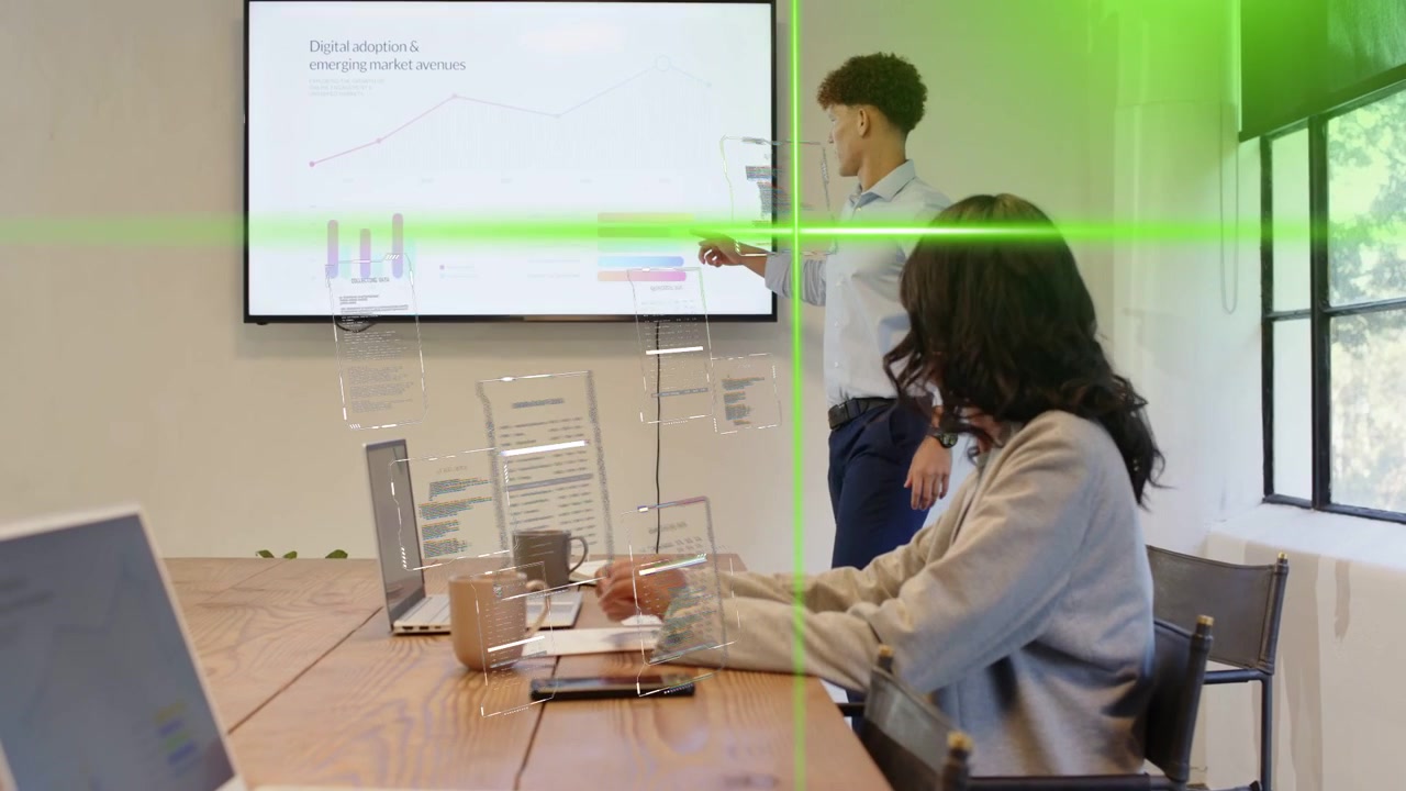 Man standing after review, pointing charts with green grid while woman using laptop for business