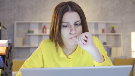 mujer joven pensativa y confundida sentada en la oficina de casa trabajando en una computadora portátil preocupada.