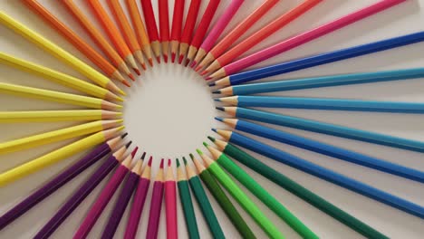 Video-of-central-composition-with-colorful-crayons-on-white-surface