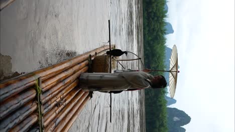 chinesisches hanfu-mädchen mit einem regenschirm öffnet die arme auf einem bambus-floß im li-fluss