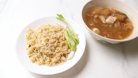 Panning-from-the-left-to-the-right-side-of-the-frame-on-a-serving-of-fried-rice-and-fish-maw-and-chicken-soup