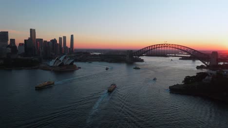 sydney opera house harbour bridge australia aerial drone nsw circular quay waterfront ferry boats city vivid orange sun sunset on horizon unique view summer skyscrapers motion circle right slowly