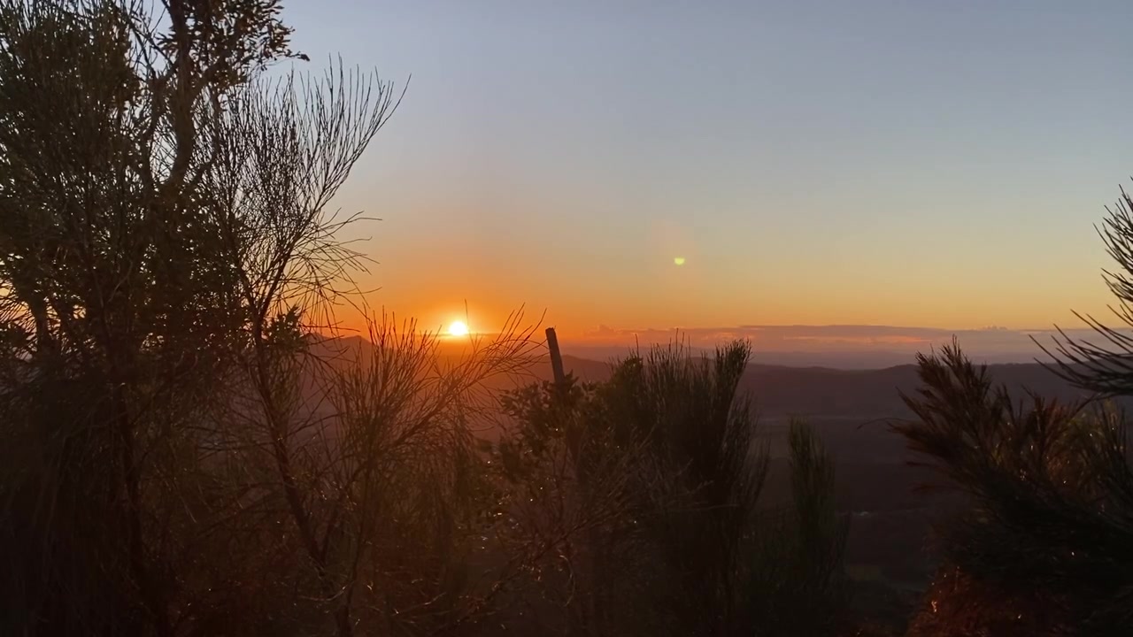 Pohled na východ slunce z úbočí hory přes malebnou divokou krajinu | 4K záběry přírody.