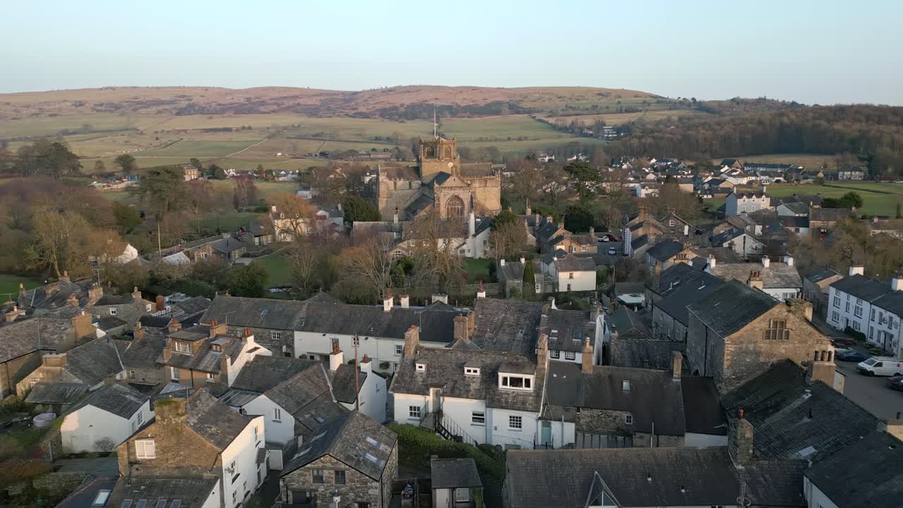clip en cámara lenta del pueblo medieval de cartmel en cumbria que muestra el histórico priorato de cartmel al atardecer en un día de invierno