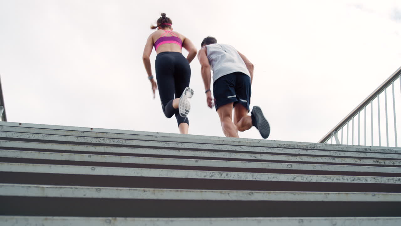 Due persone atletiche che corrono su per le scale allenandosi