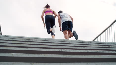 Zwei-Sportliche-Menschen-Rennen-Beim-Training-Die-Treppe-Hinauf