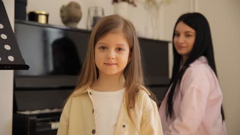 girl learns piano with supportive woman in cozy room building strong bond