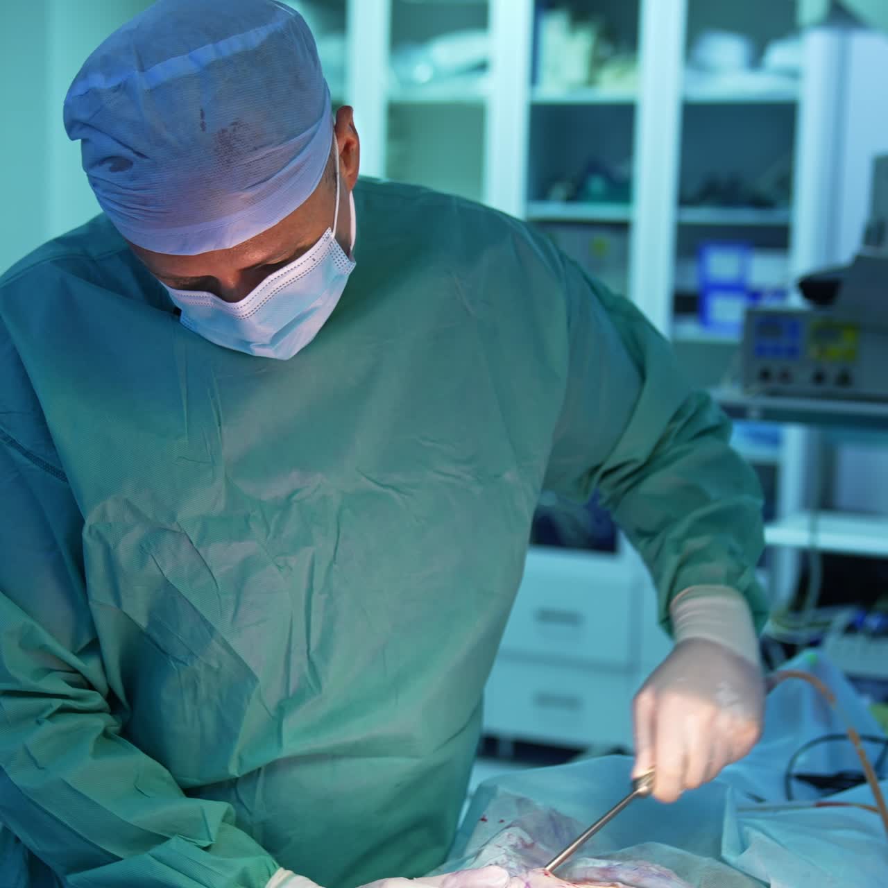 Fat removal from patient's abdomen. Professional surgeon in medical uniform performing liposuction procedure with surgical instrument in operating room