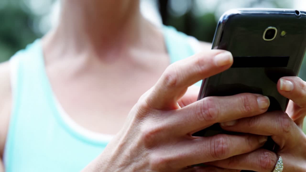 공원에서 드폰을 사용하는 여성 운동선수