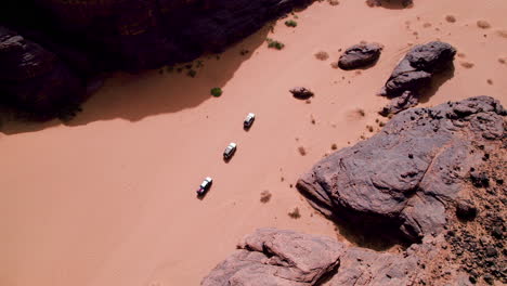 Vista-Aérea-De-Vehículos-Todoterreno-Circulando-Por-El-Desierto-Del-Sahara-En-El-Parque-Nacional-Tassili-N&#39;ajjer-En-Djanet,-Argelia