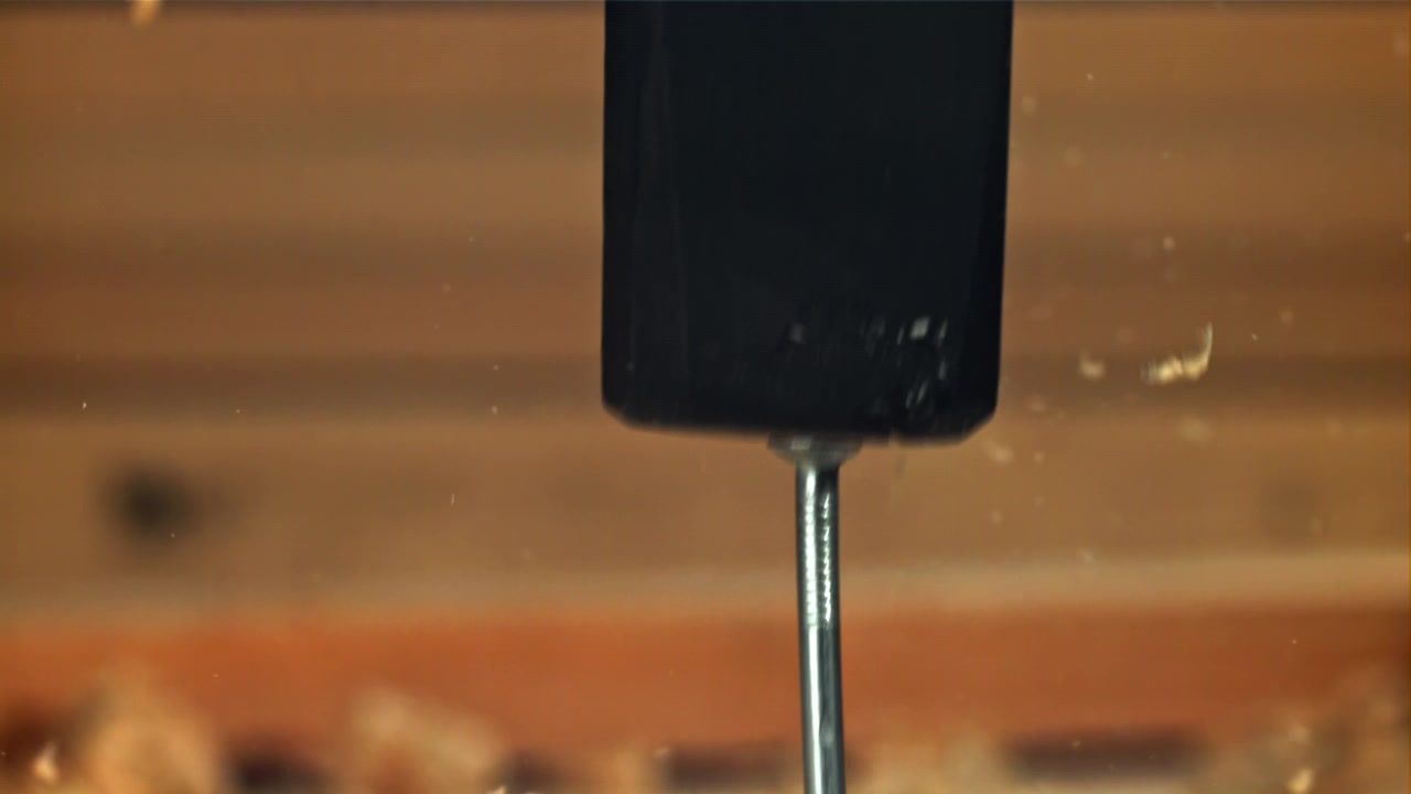Martillo clavando un clavo en madera en cámara lenta