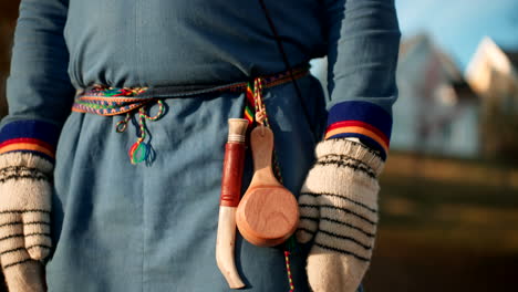 knife and wooden drinking cup hanging on the belt of sami man - sami clothing. - closeup shot