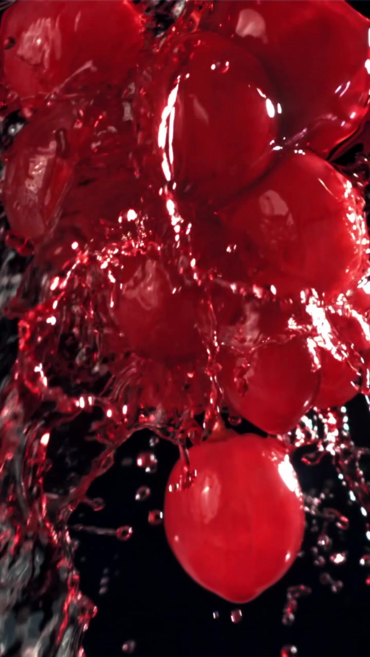 Movimento lento di acqua che schizza su uva rossa fresca.
