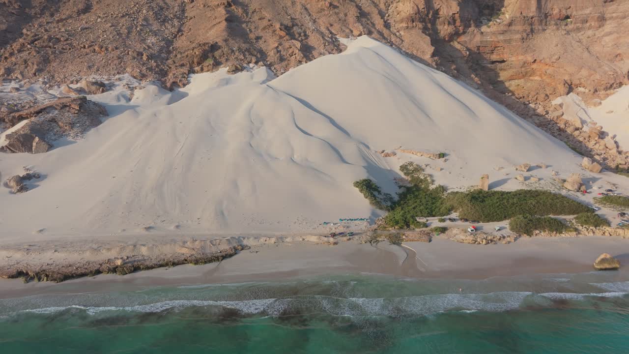Vista aerea di una spiaggia mozzafiato con dune di sabbia e camper.