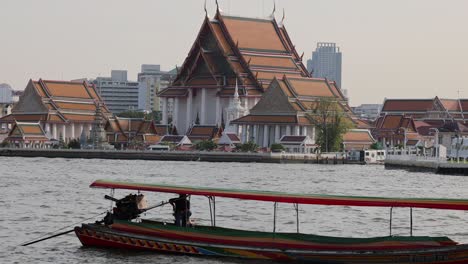 boat moves across river with temples in background