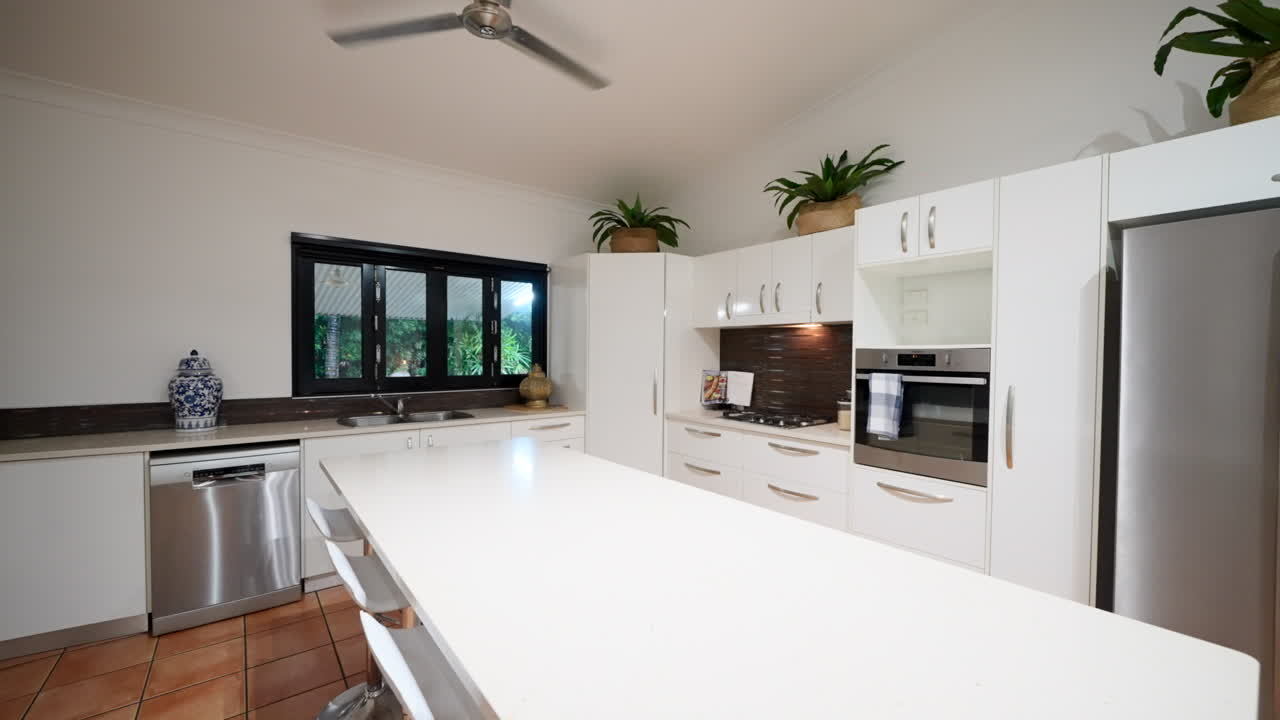 스테인리스 스 가전제품과 레트로 바 의자, 모자와 가득 찬 가방 랙으로 넓은 주방에서 살았습니다.