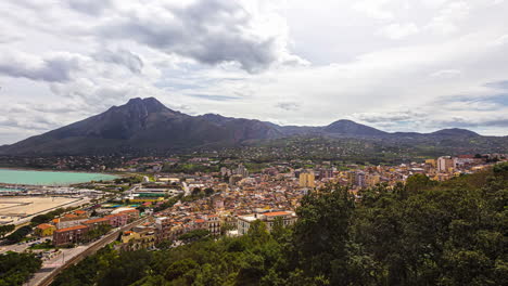 timelapse filmado sobre casas de la ciudad costera rodeadas de cordilleras en belvedere, sicilia, italia en un día nublado