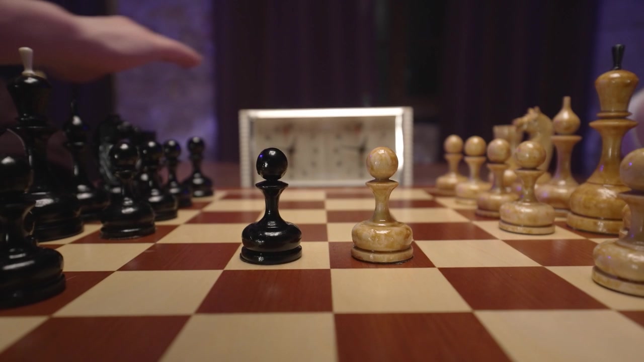 Gros plan sur des joueurs effectuant les coups d'ouverture d'une partie d'échecs