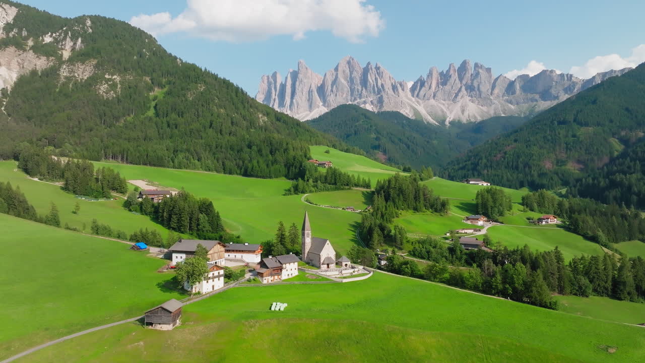 Val di Funes landscape with church of St. Magdalena nestled below rugged Dolomites peaks