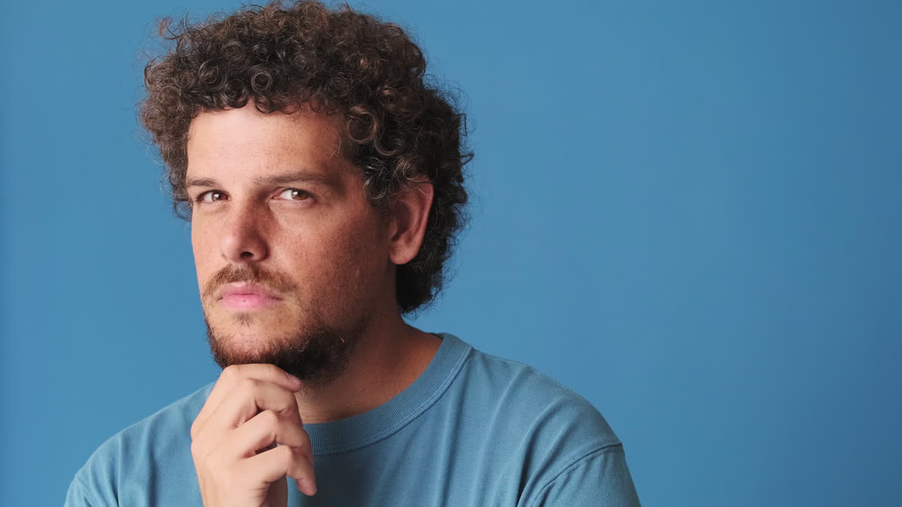 Ritratto di un uomo con capelli ricci assorto nei suoi pensieri