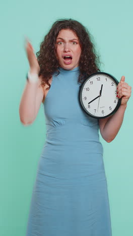 young woman with anxiety checking time on clock running late to work being in delay deadline