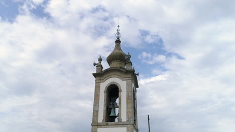 cerrar detalles de un campanario de una iglesia contra el cielo azul con nubes blancas, tiro en órbita de ángulo bajo