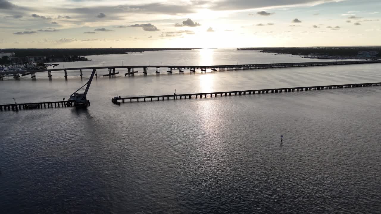 aerial flying backward away from the bridges across the Manatee River in Bradenton, Florida at the end of a warm summer day