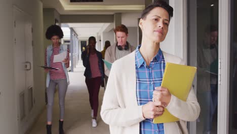 Diverse-group-of-male-and-female-business-colleagues-walking-through-corridor-and-talking