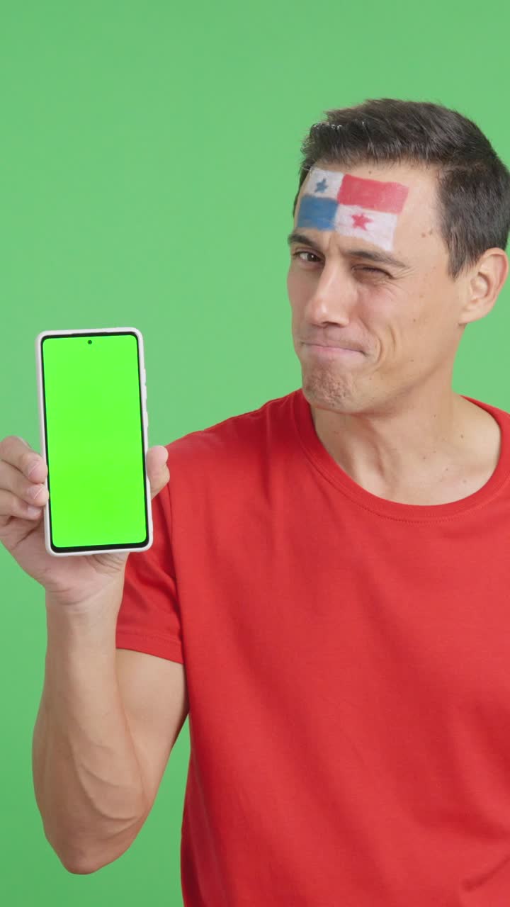 Panamanian supporter looking at his mobile smiling and showing it