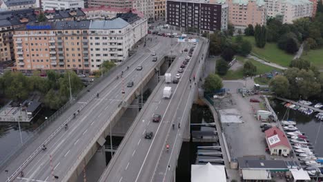 drone shot orbiting and panning down on traffic and bikers passing on liljeholmsbron towards hornstull, söder, stockholm