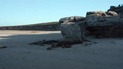 formación rocosa encontrada en una playa en la laguna langebaan en el parque nacional de la costa oeste, sudáfrica - disparo de drones en órbita