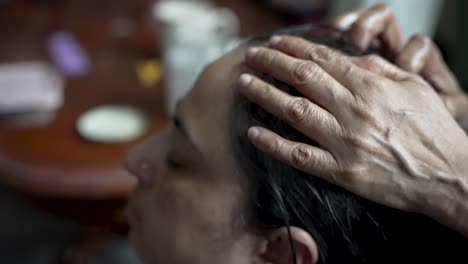 The-hairstylist-wets-the-hair-with-their-hands,-preparing-it-for-treatment-and-a-haircut,-illustrating-the-concept-of-hair-care-and-grooming