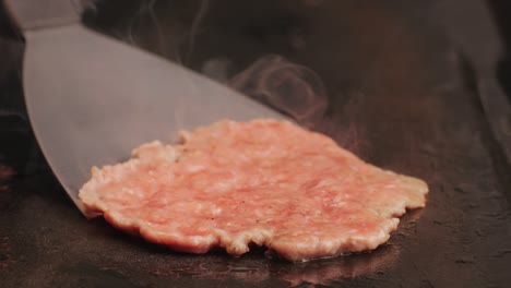 cooking american fat smash burger on grill close-up. beef or pork cutlet smashing by burger press. the chef in kitchen of the restaurant making cutlets for burgers - smash burger beefsteak. fast and street food concept. high quality 4k footage