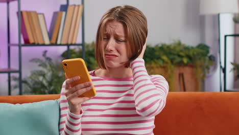 sad young woman use smartphone surprised by bad news, fortune loss, fail, lottery results, deadline