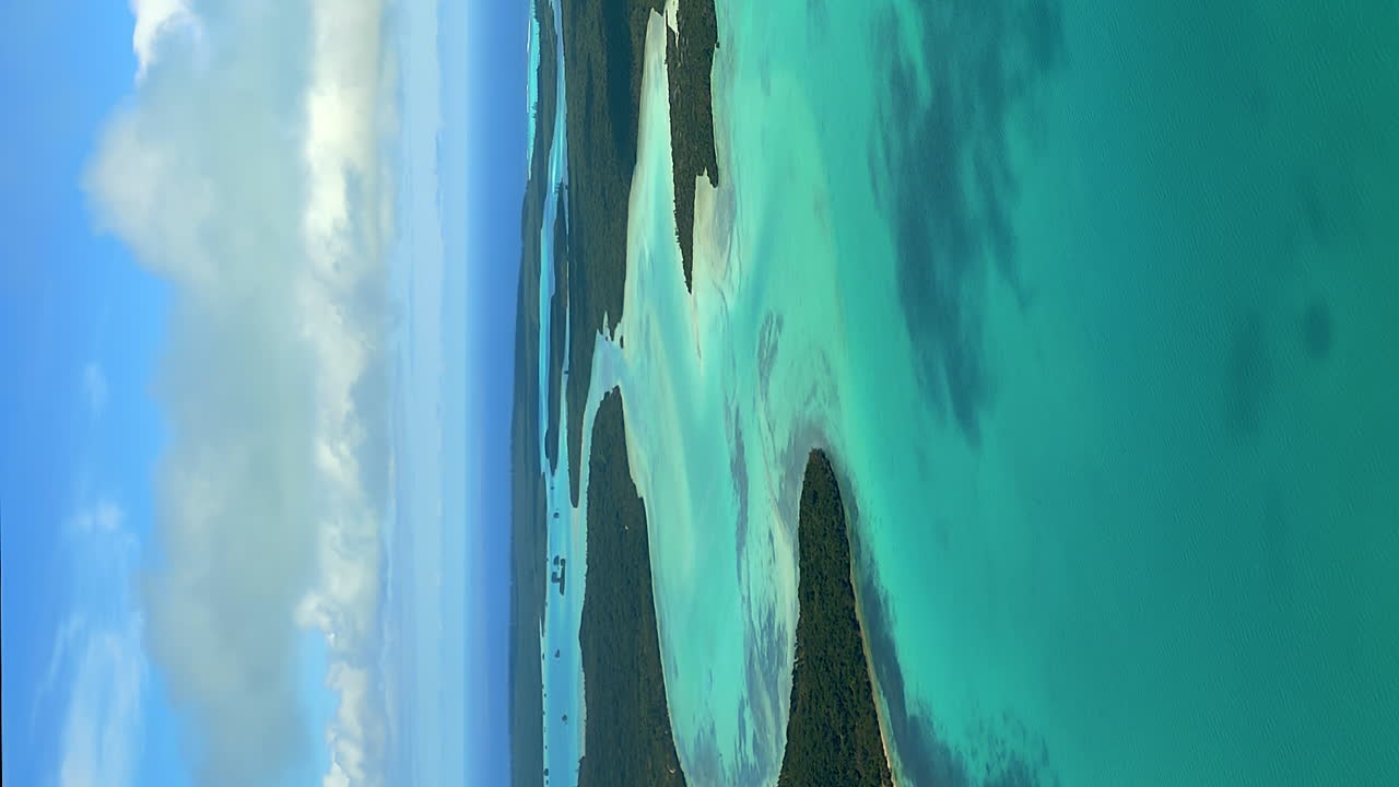 panorámica aérea tomada sobre la bahía de saint maurice en la isla de los pinos, nubes sombras en movimiento