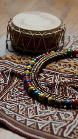 colorful beaded necklace on ethnic fabric with drum