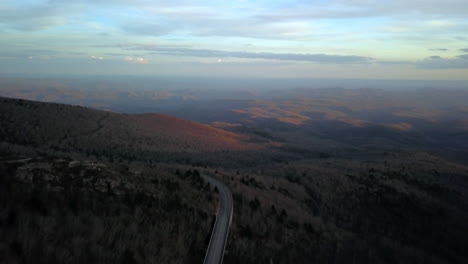 Blue-Ridge-Parkway-En-Primer-Plano-Con-Montañas-Al-Atardecer-En-El-Fondo-En-El-Condado-De-Avery-Carolina-Del-Norte