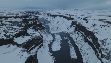 vista aérea del cañón del río glacial en el frío paisaje invernal de islandia, toma de dron