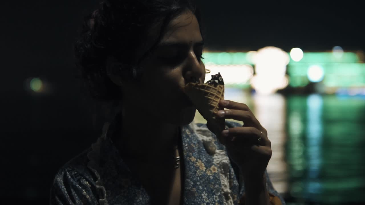 imágenes cinematográficas en cámara lenta de una modelo de moda comiendo helado con el océano en el fondo en goa, india, slomo