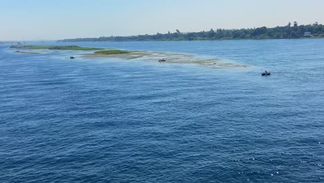 Many-fishermen-sailing-along-Nile-River-water-while-a-cruise-navigates-in-Egypt