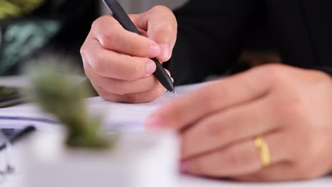 close up of business woman hands writing a business document at workplace.