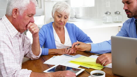 Mature-couple-filling-some-formal-documents-with-man