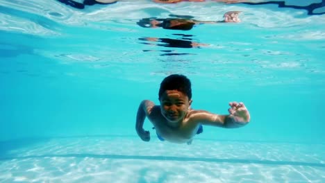 Niño-Nadando-Bajo-El-Agua-En-La-Piscina