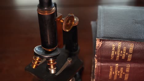 viejos libros veterinarios antiguos y un microscopio vintage - cierre aislado