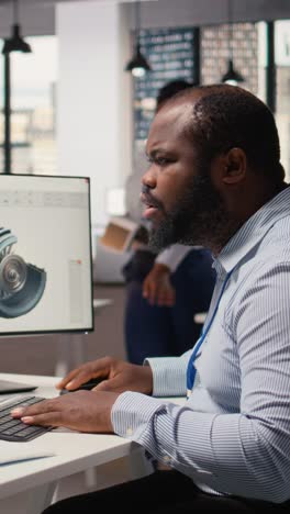 Technician using CAD program on PC to optimize wind turbine design