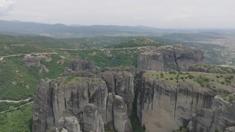 panoramic aerial over striking rock formations with monastery of holy trinity