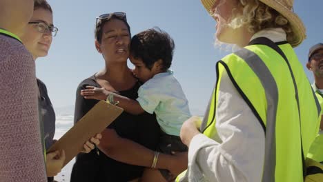 voluntarios interactuando entre sí en la playa 4k