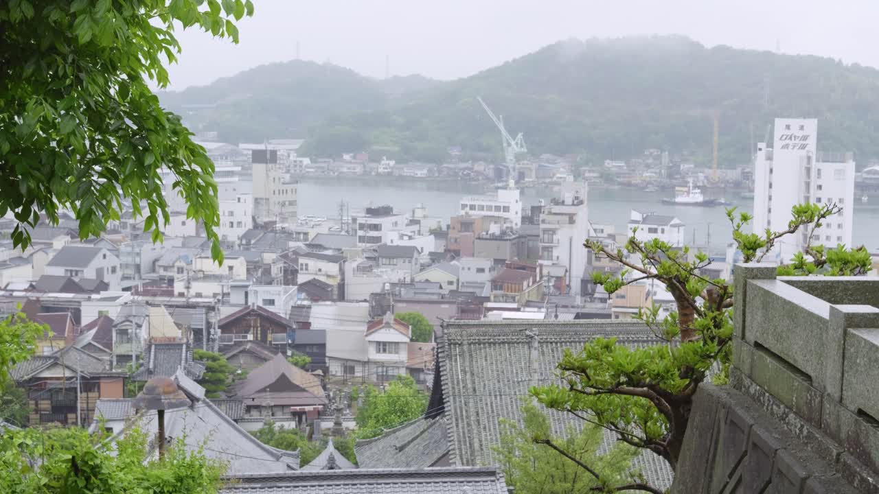 Slow motion tilt up over Onomichi landscape with cloudy sky