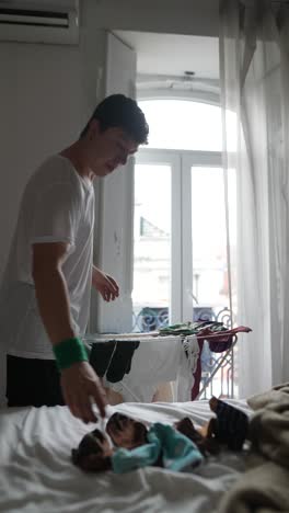 young person doing laundry in a bedroom