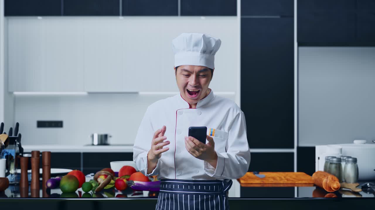 chef mirando el teléfono inteligente en la cocina